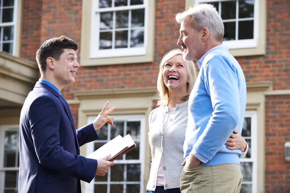 couple with estate agent selling home